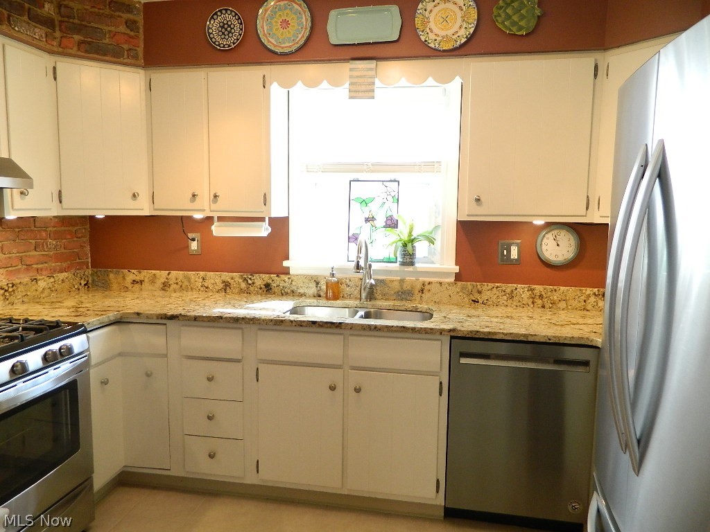 1604 Lyndhurst Road Lyndhurst, OH 44124 - Photo 6 of 35 Gorgeous White Kitchen with Brick Accents, New Granite Counters, Stainless Appliances, Newer Deep Stainless Sink and New Faucet! Additional Outlet Added and Plumbing Replaced Under the Kitchen Sink.