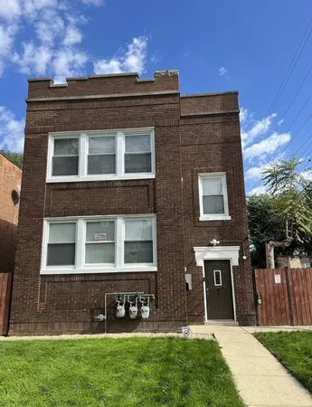 a large brick building with many windows and a yard