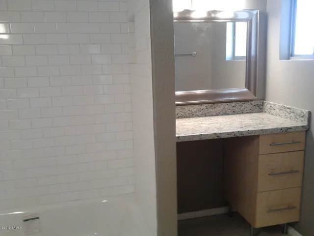 a bathroom with a granite countertop sink and vanity