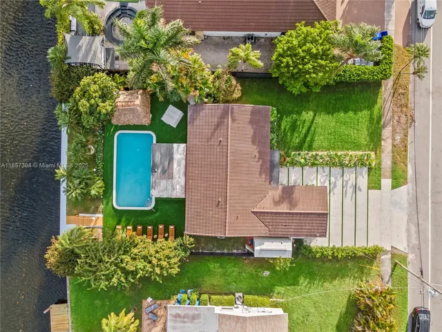 an aerial view of residential houses with outdoor space and lake view