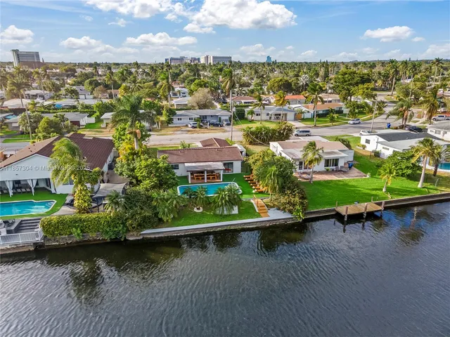 an aerial view of residential houses with outdoor space and lake view