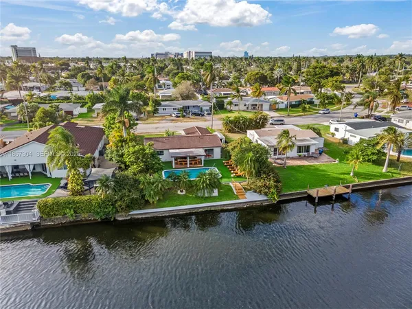 an aerial view of residential houses with outdoor space and lake view
