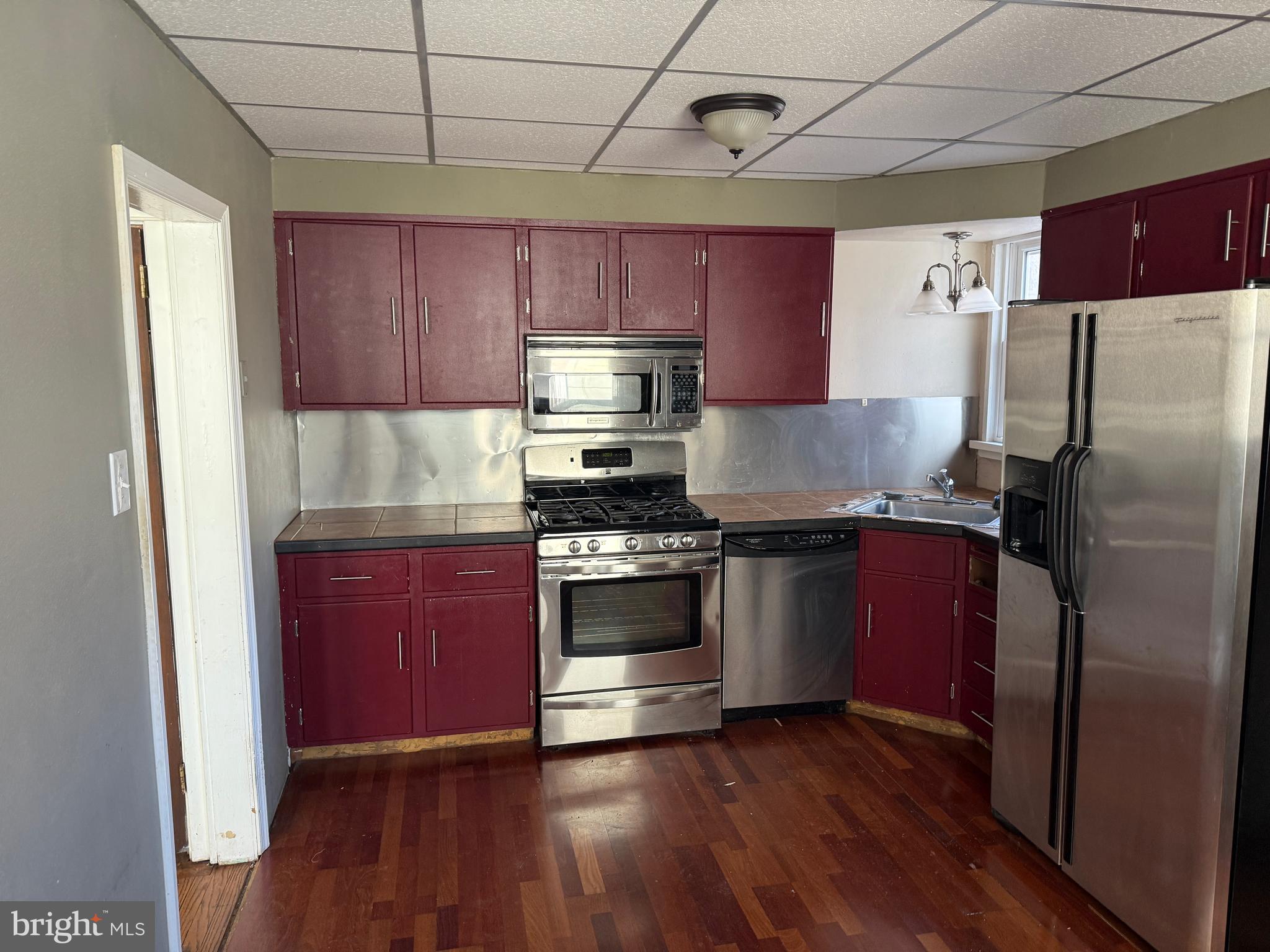 4049 Marshall Road Upper Darby, PA 19026 - Photo 11 of 26 a kitchen with stainless steel appliances granite countertop a refrigerator a sink dishwasher a stove and wooden floor