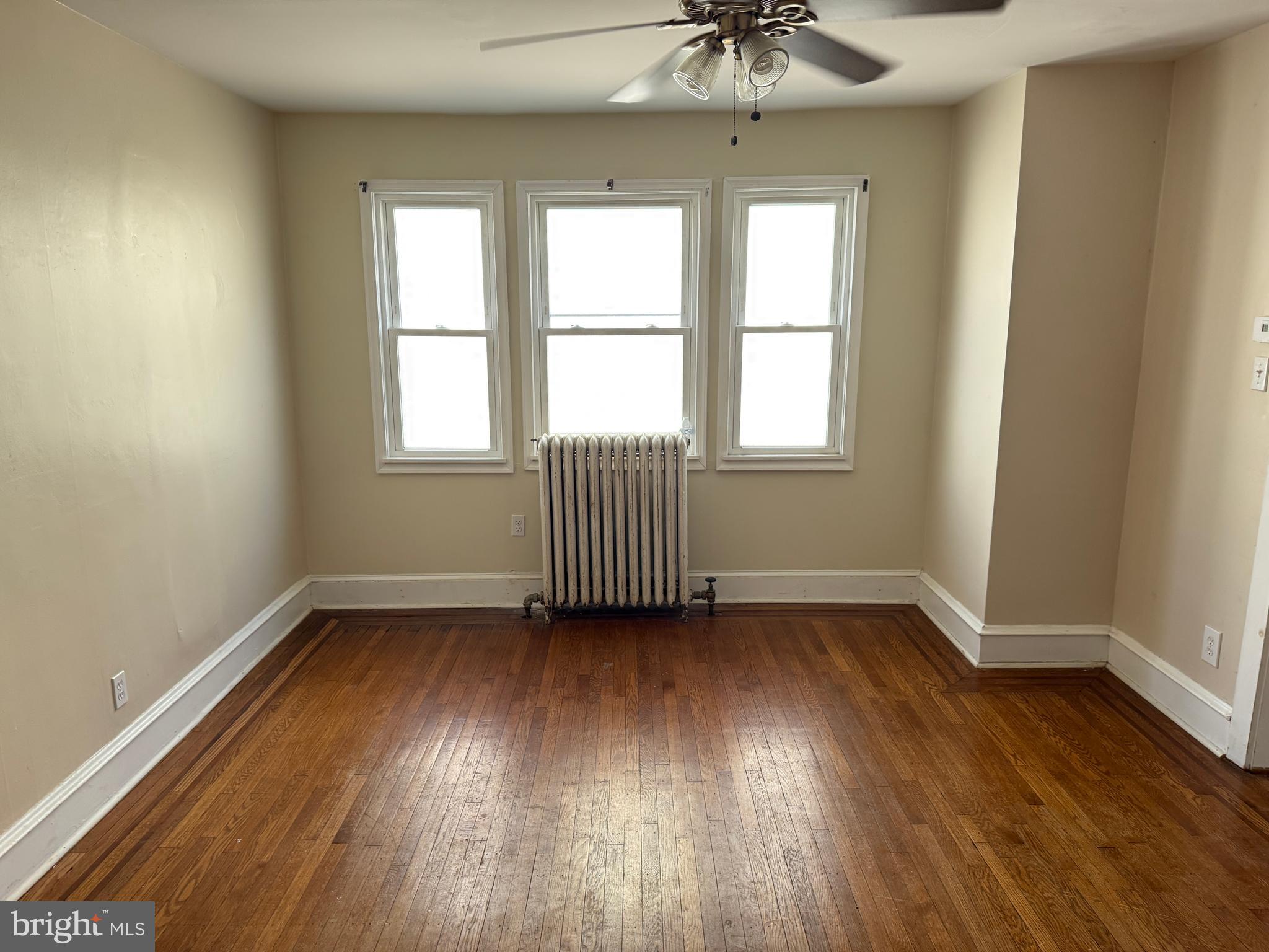 4049 Marshall Road Upper Darby, PA 19026 - Photo 7 of 26 an empty room with wooden floor chandelier and windows