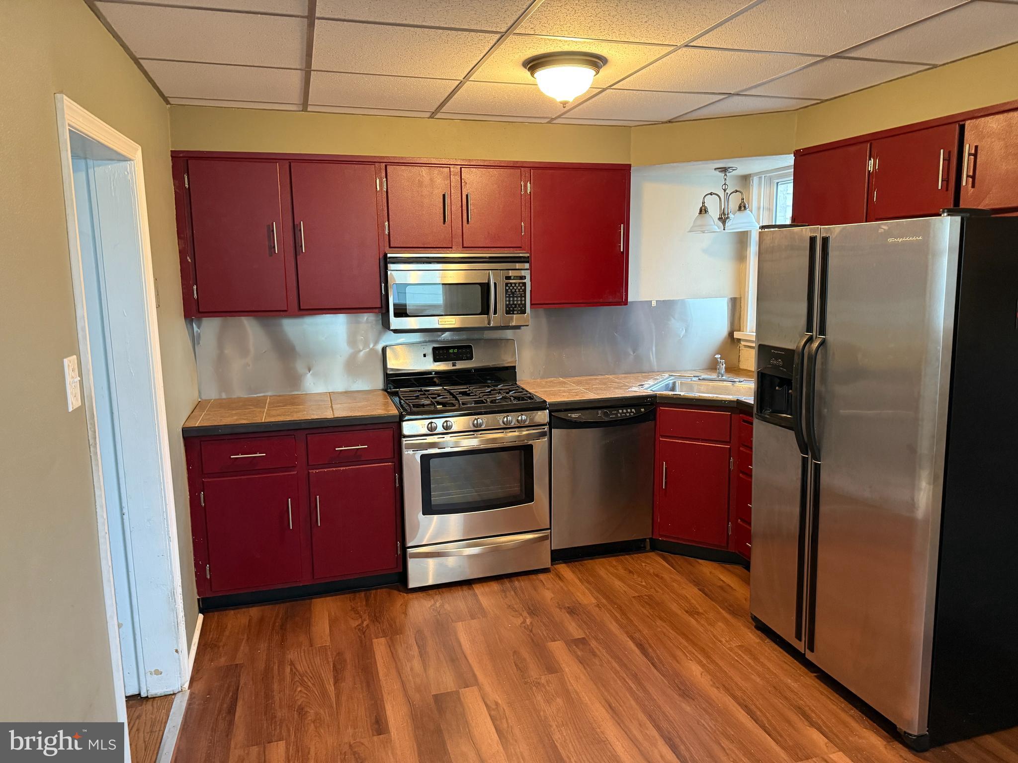 4049 Marshall Road Upper Darby, PA 19026 - Photo 10 of 26 a kitchen with granite countertop a refrigerator stove and microwave