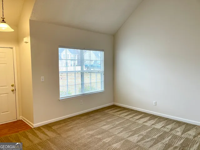 a view of a bedroom with wooden floor and windows