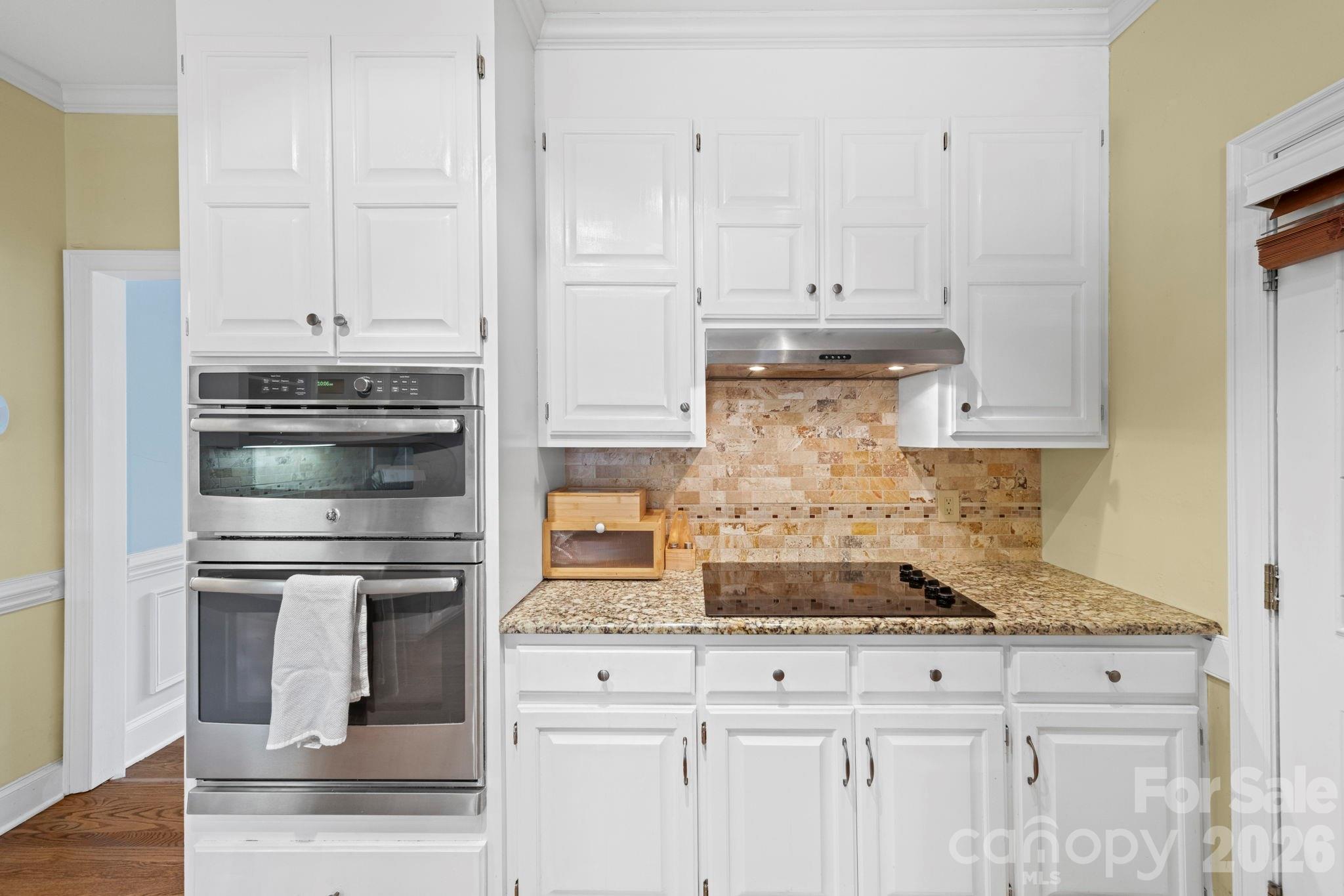 1265 Braeburn Road Northwest Concord, NC 28027 - Photo 12 of 48 a kitchen with granite countertop white cabinets and stainless steel appliances