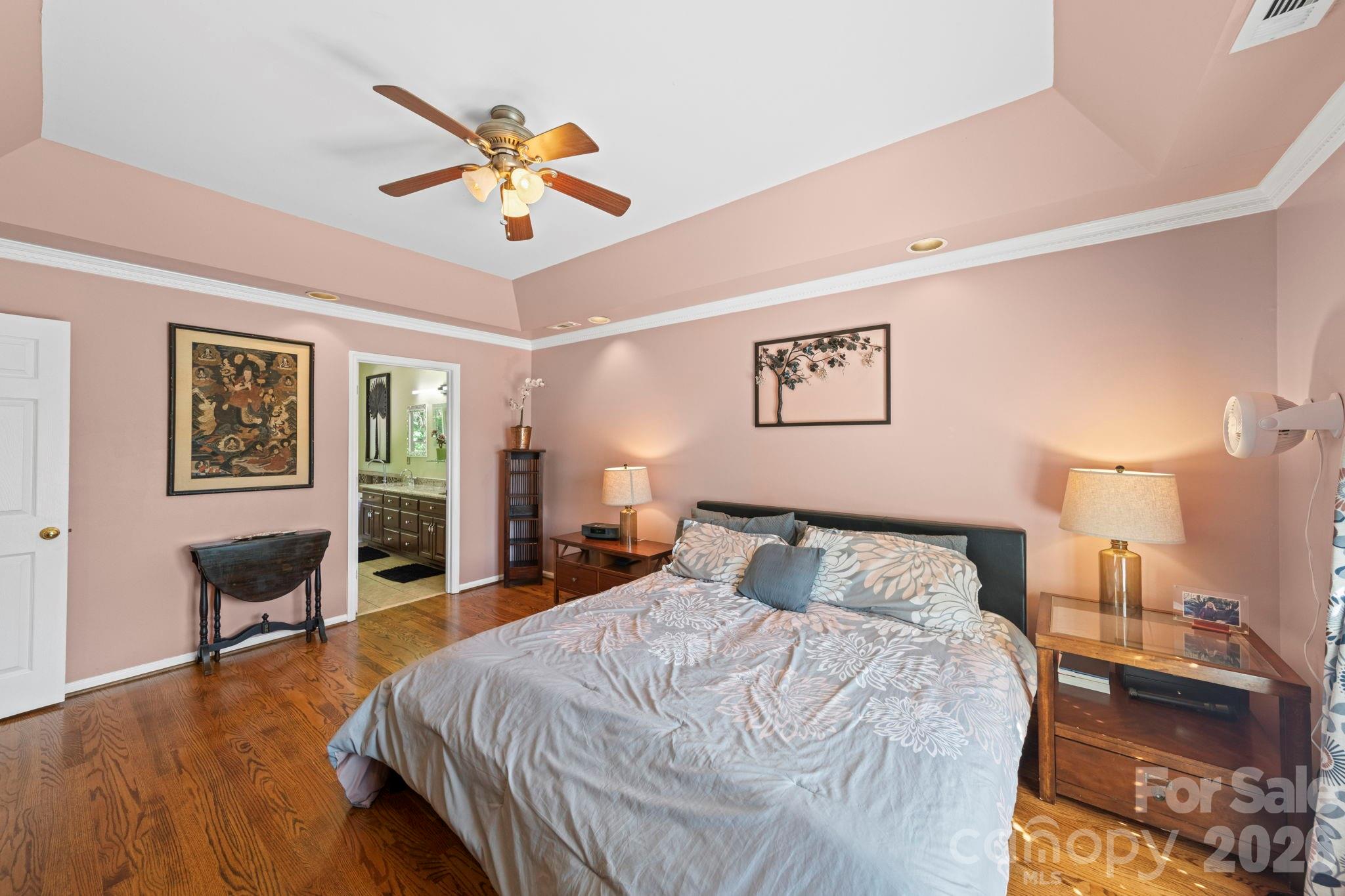 1265 Braeburn Road Northwest Concord, NC 28027 - Photo 24 of 48 a bedroom with a large bed and a chandelier