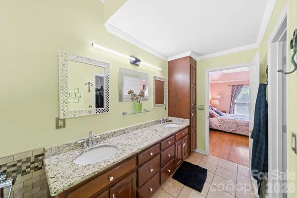 a bathroom with a granite countertop double vanity sink and a mirror