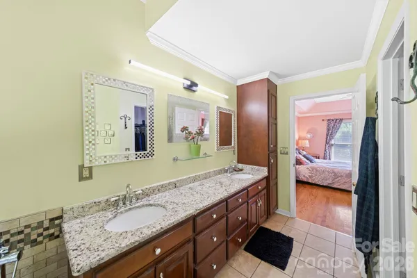 a bathroom with a granite countertop double vanity sink and a mirror