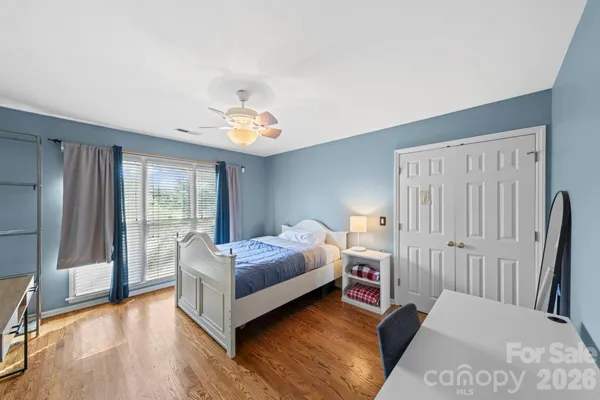 a bedroom with a bed and wooden floor