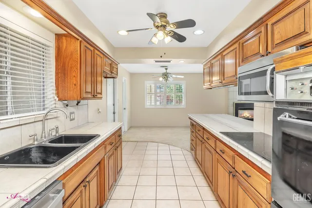 a kitchen with stainless steel appliances granite countertop a sink stove and cabinets