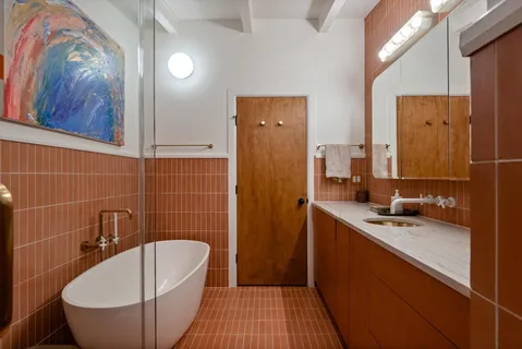 a bathroom with a granite countertop sink and a bathtub