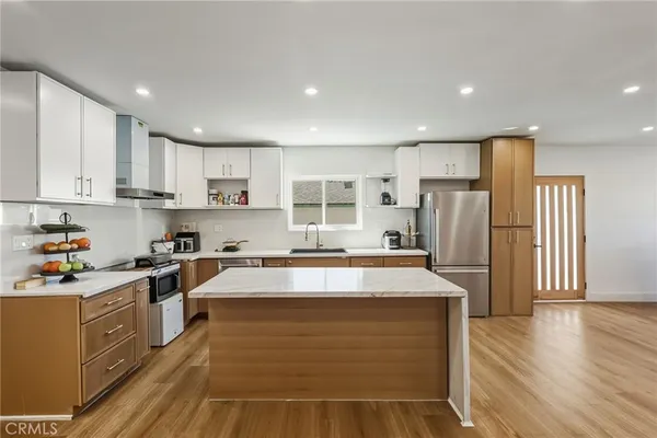 a kitchen with stainless steel appliances granite countertop a sink stove and refrigerator