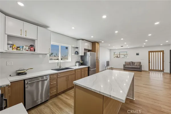 a kitchen with stainless steel appliances granite countertop a sink stove and refrigerator
