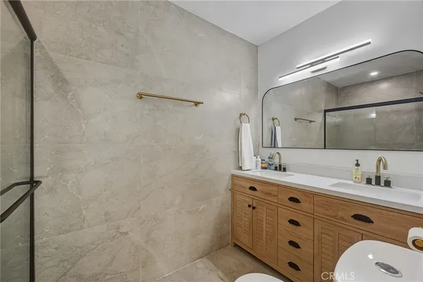 a bathroom with a double vanity sink a mirror and shower