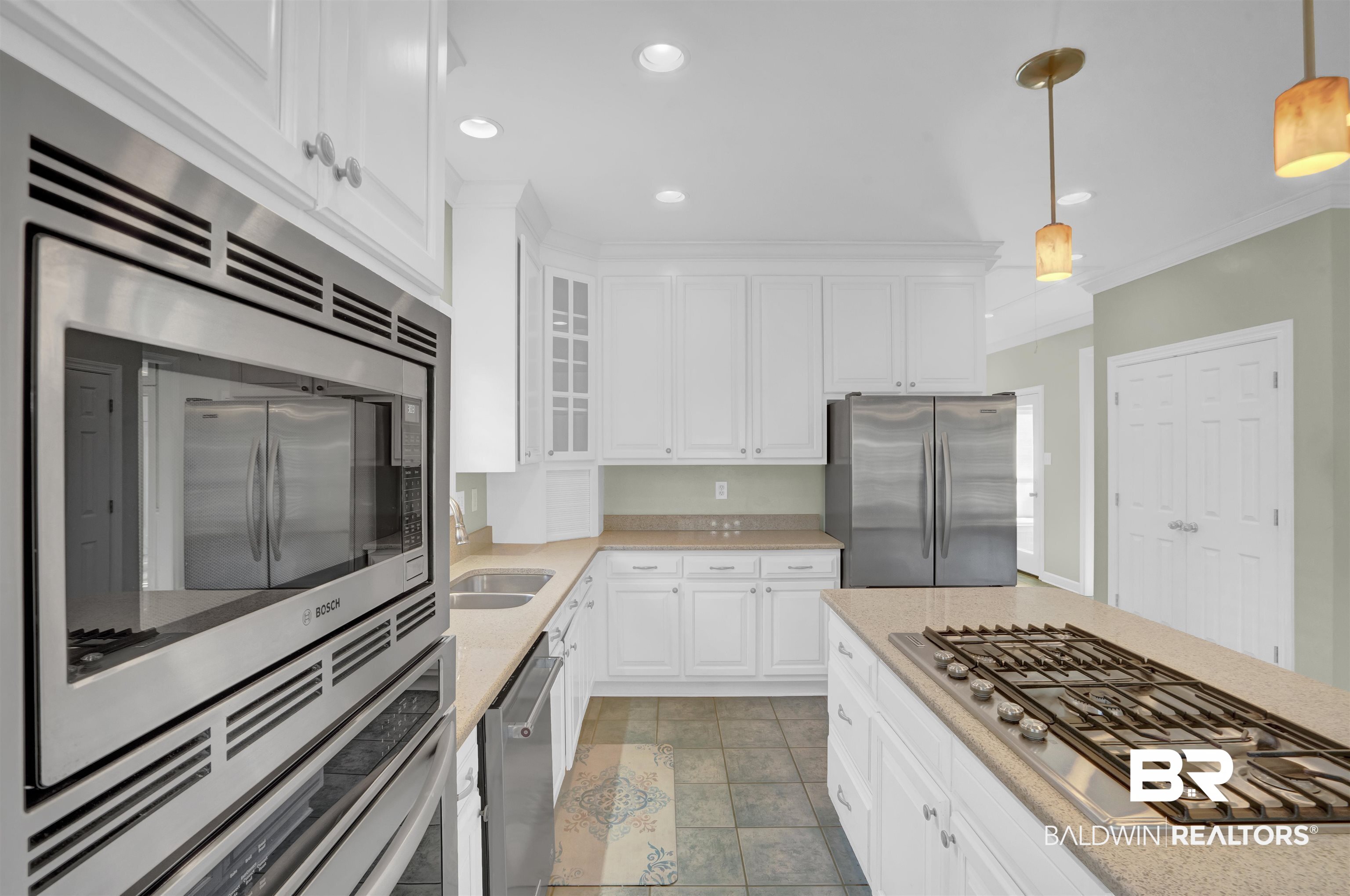 111 Beaver Dam Road Fairhope, AL 36532 - Photo 16 of 51 Kitchen with white cabinetry, pendant lighting, stainless steel appliances, crown molding, and sink