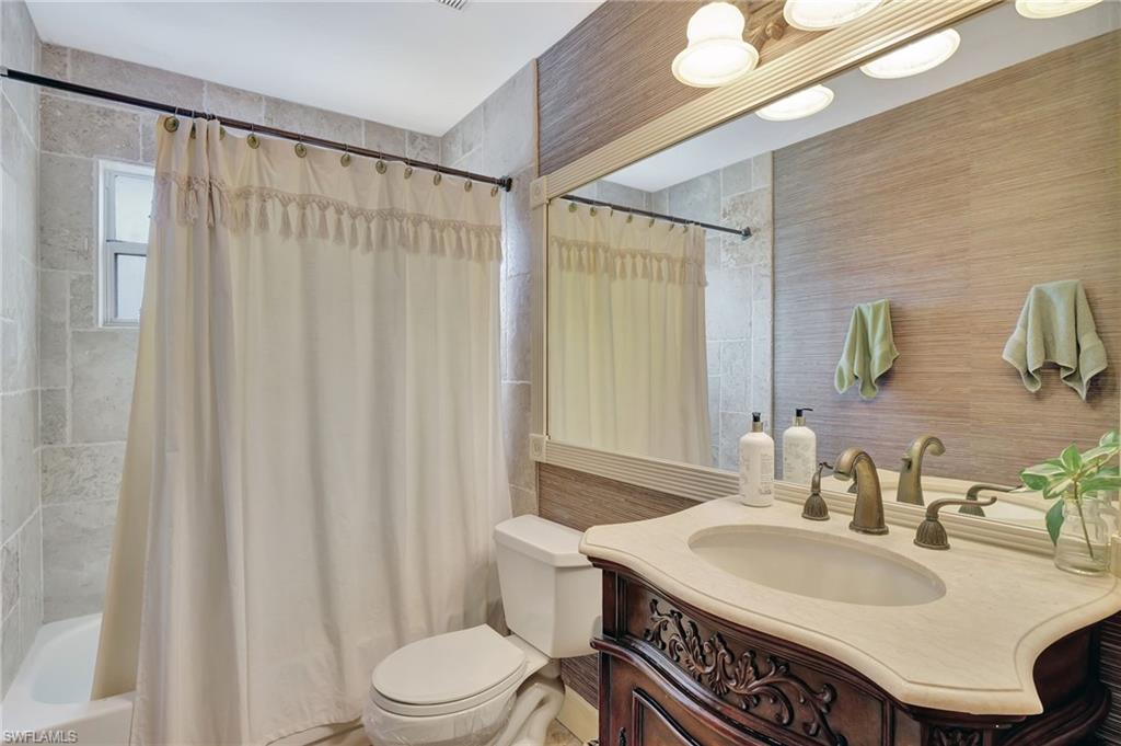 2103 Tama Circle, Unit 202 Naples, FL 34112 - Photo 22 of 28 a bathroom with a sink a toilet and shower curtain