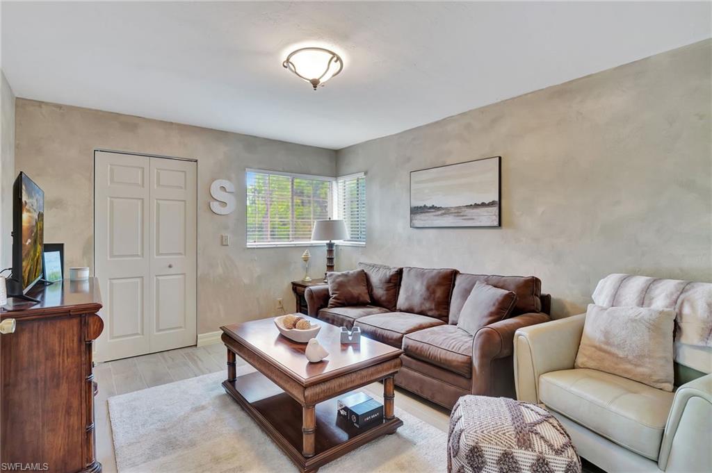 2103 Tama Circle, Unit 202 Naples, FL 34112 - Photo 24 of 28 a living room with furniture and a flat screen tv