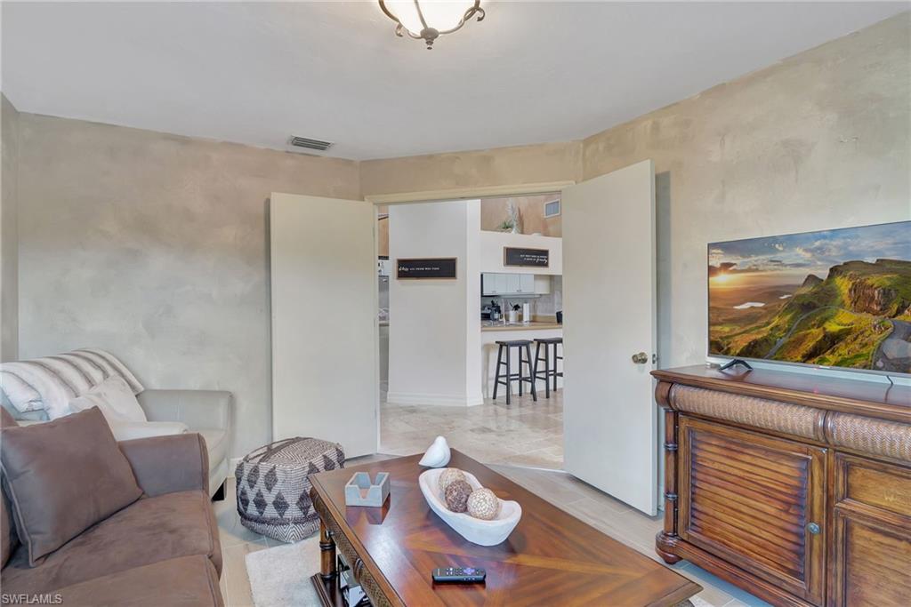 2103 Tama Circle, Unit 202 Naples, FL 34112 - Photo 26 of 28 a living room with furniture and a flat screen tv