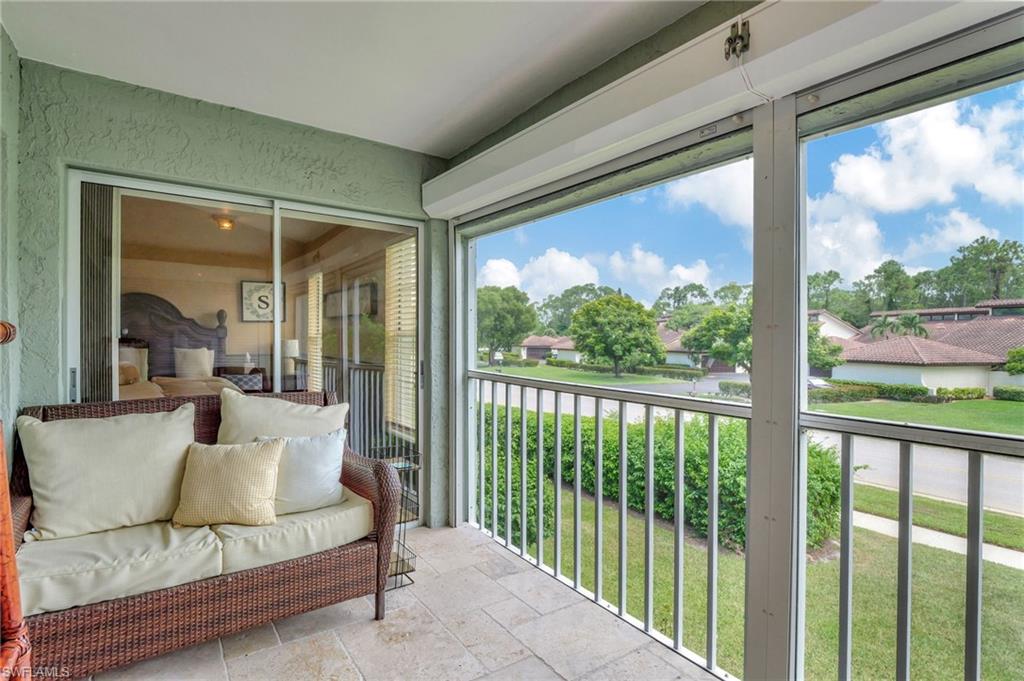 2103 Tama Circle, Unit 202 Naples, FL 34112 - Photo 28 of 28 a balcony view with a couch and large windows
