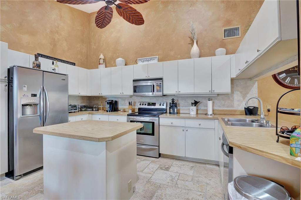 2103 Tama Circle, Unit 202 Naples, FL 34112 - Photo 7 of 28 a kitchen with a sink a stove and refrigerator