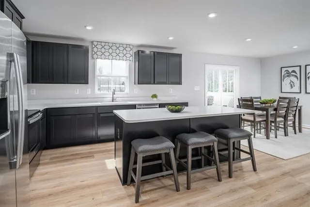 a kitchen with a dining table chairs sink and cabinets