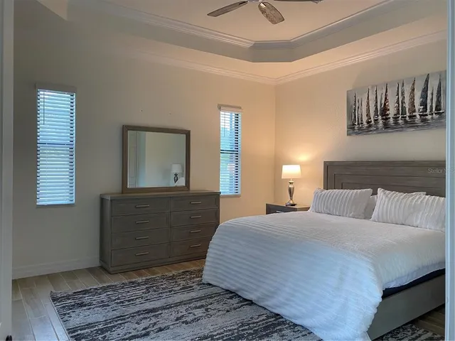 a bedroom with a bed and a mirror on the dresser