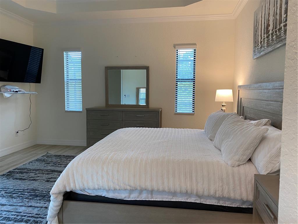 17525 Hickok Belt Loop Bradenton, FL 34211 - Photo 12 of 31 a bedroom with a bed and a flat screen tv