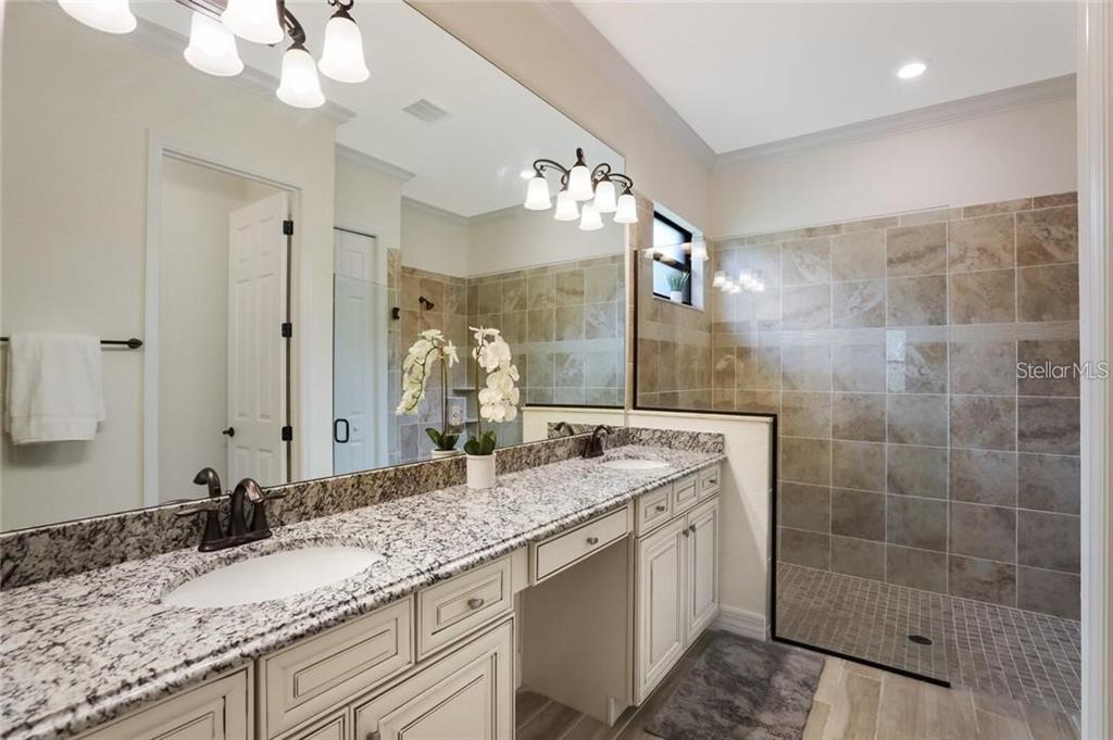 17525 Hickok Belt Loop Bradenton, FL 34211 - Photo 14 of 31 a bathroom with a granite countertop double vanity sink mirror and shower