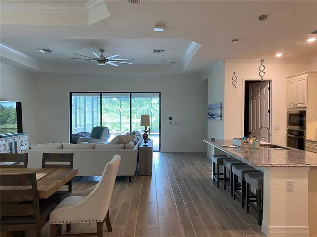a living room with lots of furniture wooden floor and a table