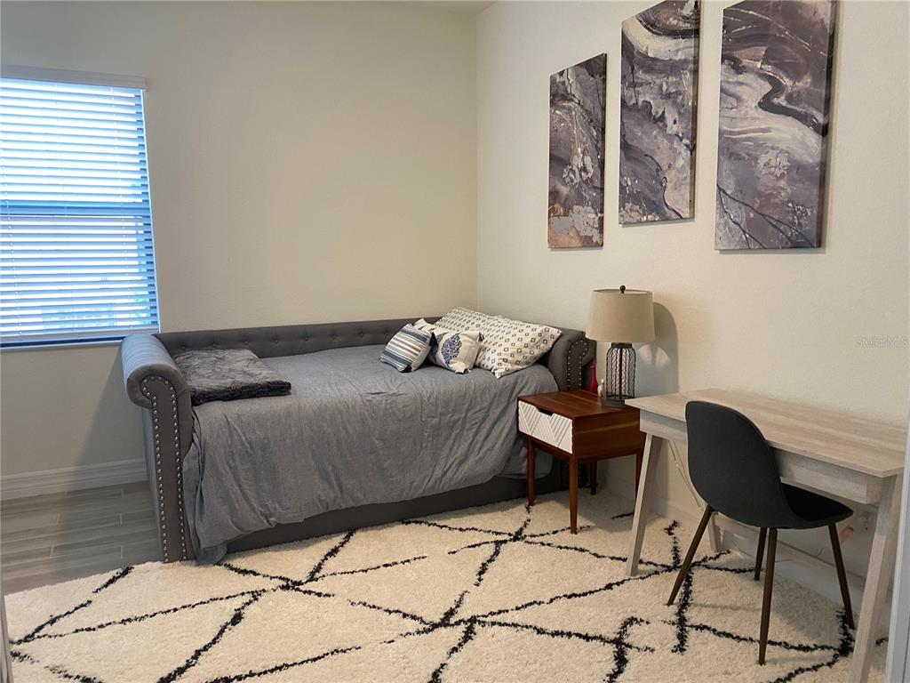 17525 Hickok Belt Loop Bradenton, FL 34211 - Photo 24 of 31 a bedroom with a bed and chair