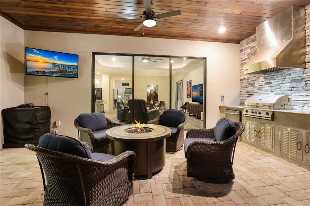 17525 Hickok Belt Loop Bradenton, FL 34211 - Photo 29 of 31 a dining room with furniture a rug and a flat screen tv