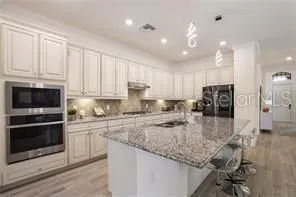 a kitchen with kitchen island granite countertop a stove sink and microwave