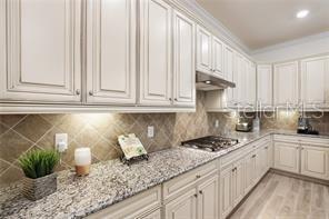 17525 Hickok Belt Loop Bradenton, FL 34211 - Photo 6 of 31 a kitchen with stainless steel appliances white cabinets and a granite counter tops