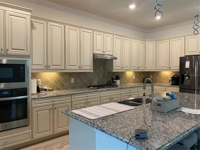 a kitchen with granite countertop a sink stove and cabinets