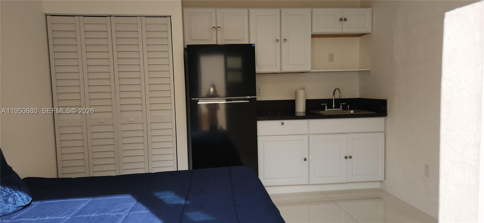 17930 Southwest 136th Avenue, Unit B Miami, FL 33177 - Photo 3 of 4 a kitchen with a refrigerator and cabinets