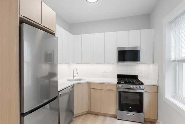 a kitchen with white cabinets and stainless steel appliances
