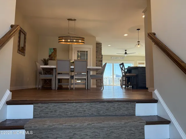 a living room with couches and a dining table with wooden floor