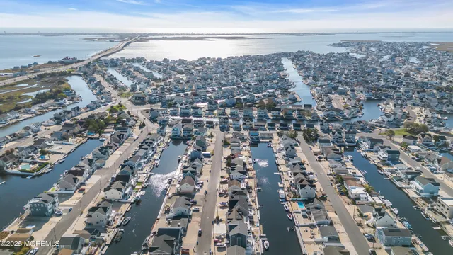 an aerial view of a city with lots of residential buildings and ocean view in back