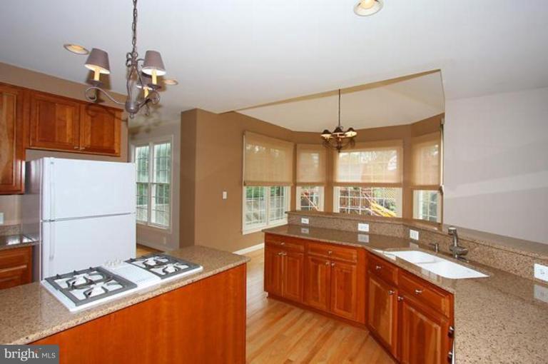 5200 Ridgefield Road Bethesda, MD 20816 - Photo 4 of 15 a kitchen with stainless steel appliances kitchen island granite countertop a sink stove and refrigerator