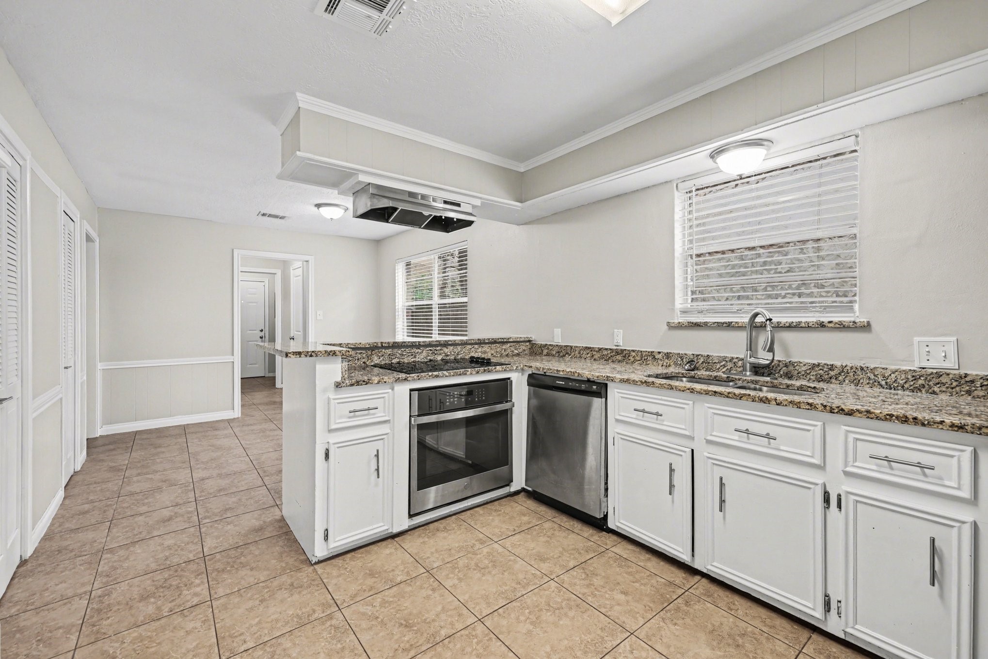 107 Carriage Lane Conroe, TX 77385 - Photo 16 of 26 a kitchen with granite countertop a sink stove and cabinets