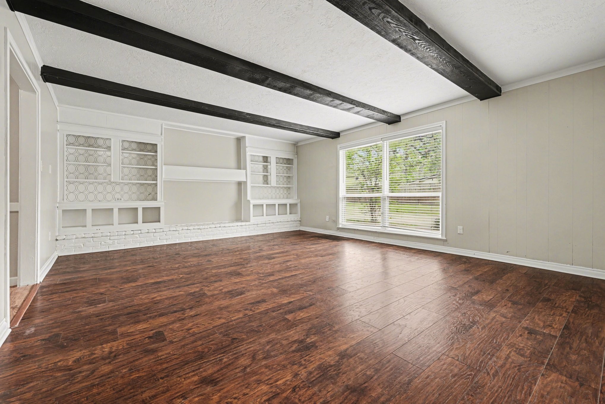 107 Carriage Lane Conroe, TX 77385 - Photo 3 of 26 an empty room with wooden floor and windows