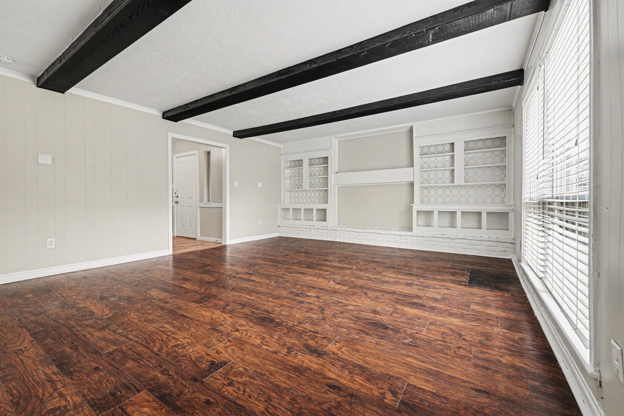 107 Carriage Lane Conroe, TX 77385 - Photo 4 of 26 a view of an empty room with wooden floor and a window