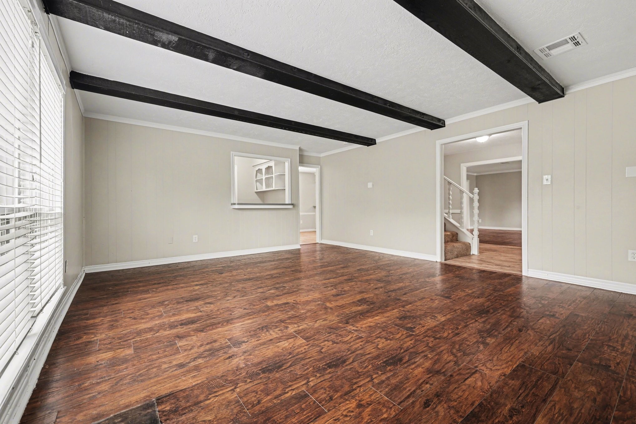 107 Carriage Lane Conroe, TX 77385 - Photo 5 of 26 a view of an empty room with wooden floor and a window