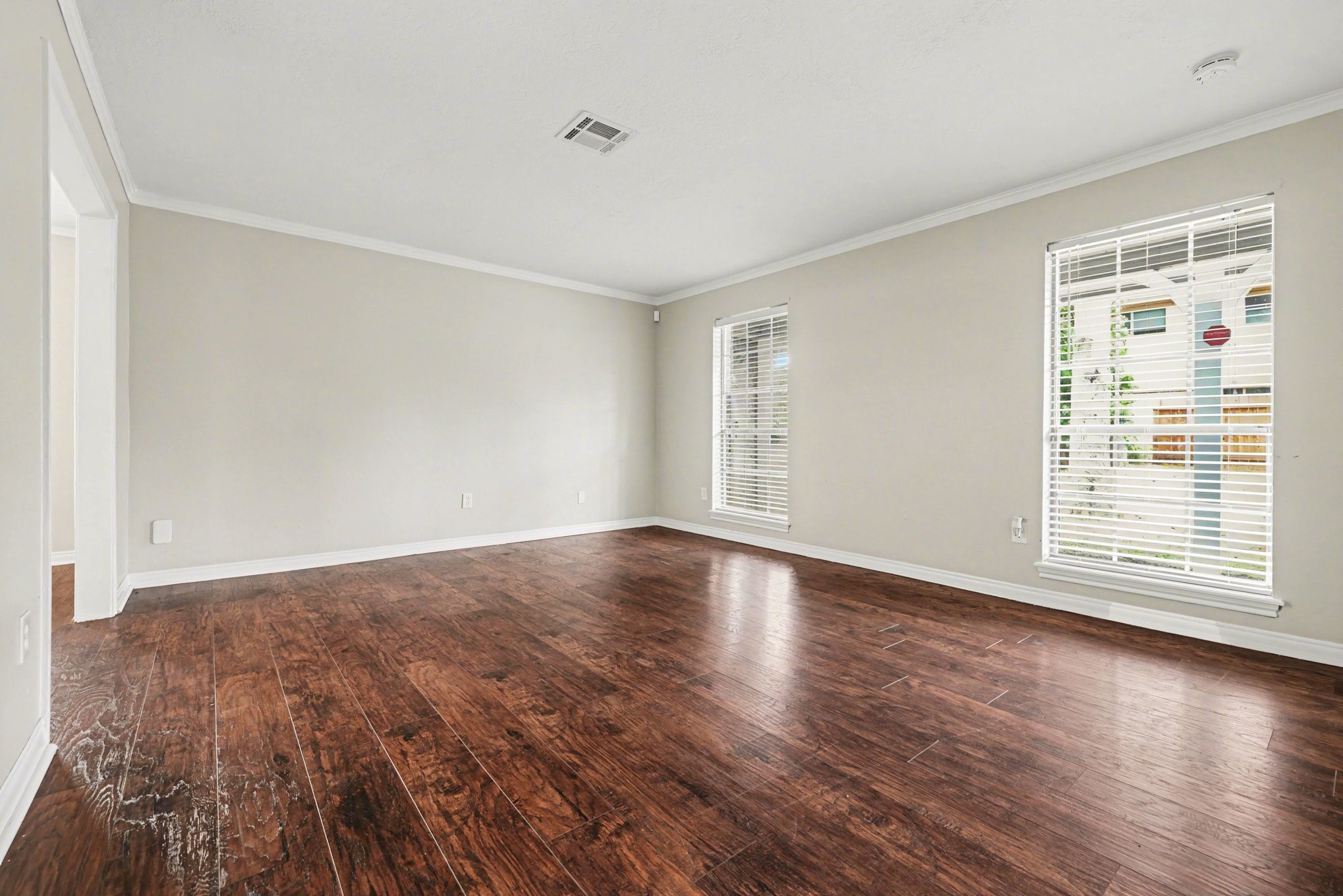 107 Carriage Lane Conroe, TX 77385 - Photo 7 of 26 a view of an empty room with wooden floor and a window