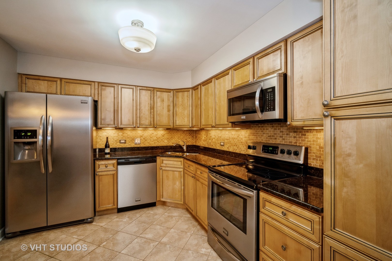 1088 Shermer Road, Unit 203 Northbrook, IL 60062 - Photo 3 of 15 a kitchen with granite countertop a refrigerator stove and microwave