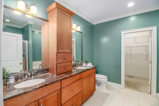 a bathroom with a double vanity sink toilet and shower