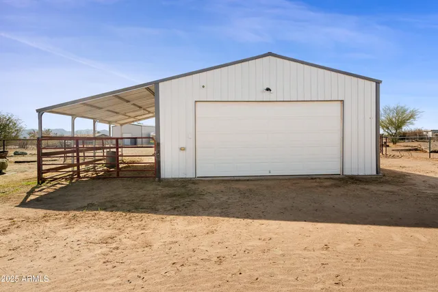 a view of a dry yard with wooden fence