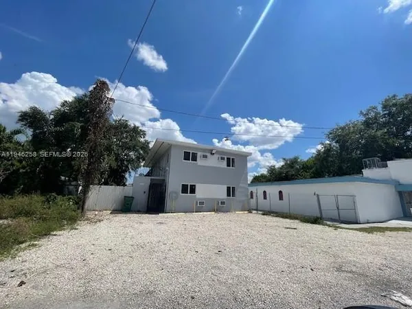 a view of a house with a yard and a large tree